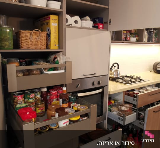 ארונות מטבח מאורגנים עם מוצרי מזון וכלים